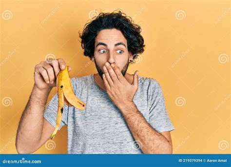 Handsome Hispanic Man Holding Banana Peel Covering Mouth with Hand ...