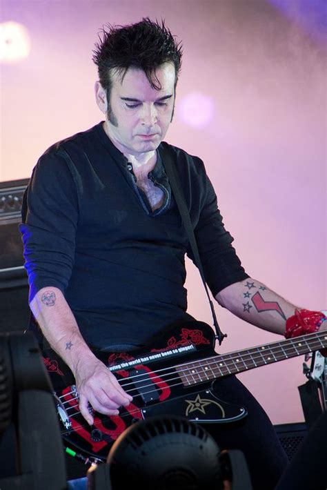 [Color photo of Simon Gallup playing a bass, on which is a sticker reading:] youholdmehypnotised ...