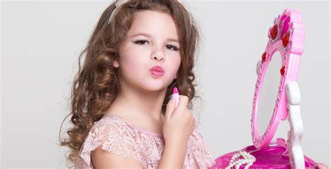 Cute little girl with lipstick applying makeup, glamour kid - Beating Trauma