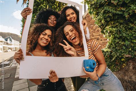 Excited friends with blank photo frame Stock Photo | Adobe Stock