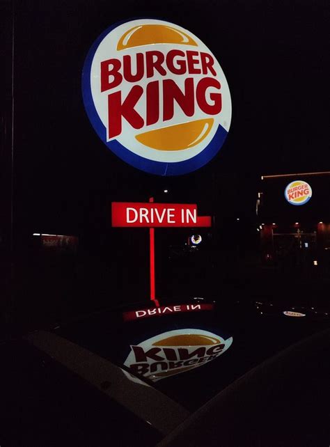 a burger king drive in sign lit up at night