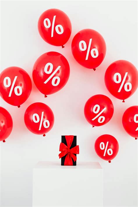 A Gift With Red Ribbon in Between Red Balloons With Percentage Symbols on a White Background ...