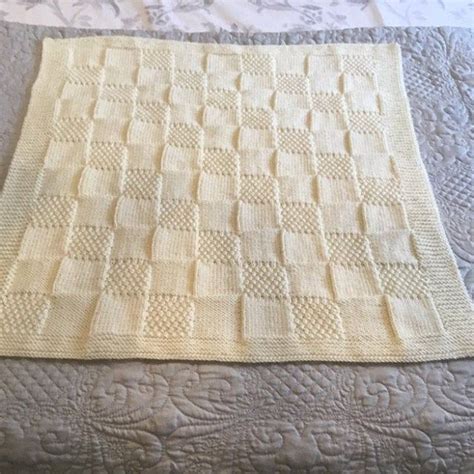 a white crocheted blanket sitting on top of a bed