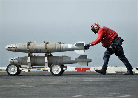 Aviation Ordnanceman moving Mk-82 munitions on the USS Abraham Lincoin ...