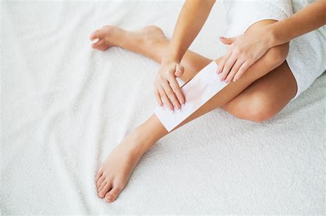 Premium Photo | Waxing. beautician waxing woman's leg in spa salon