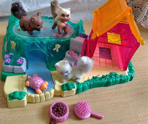 there is a toy house with animals in the yard and toys on the table next to it