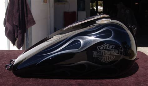 the motorcycle is shiny and black with flames on it's side panel, as well as an emblem