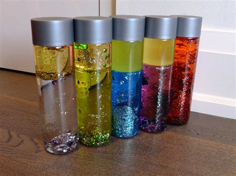 DIY sensory bottles! Some food colouring in water, sparkles and finish off with regular cooking ...