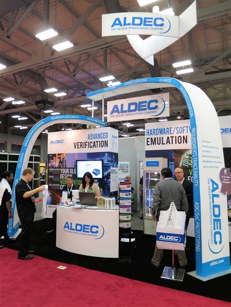 people standing in front of an albe booth at a trade show, with the name albe on it