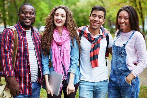 Portrait of happy college students standing together outdoors - Stock Photo - Dissolve