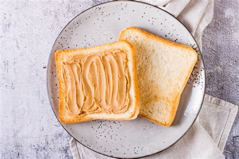 Peanut butter sandwich on toasted bread on a plate on the table. Top view. Closeup 15225588 ...