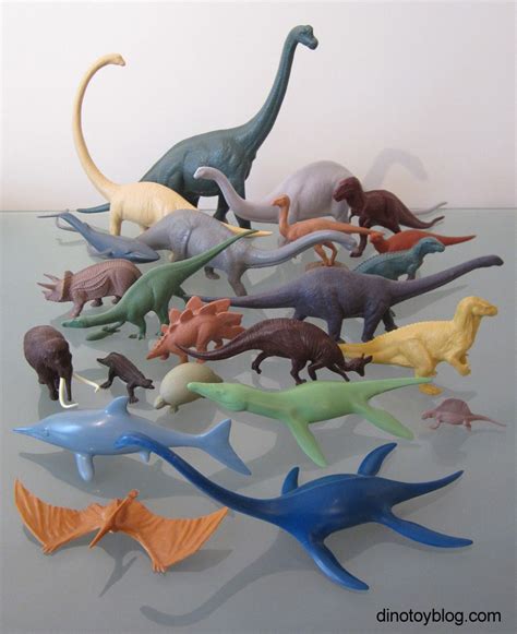 a group of plastic dinosaurs sitting on top of a table