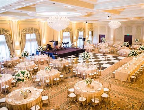 a banquet hall with tables, chairs and chandeliers set up for a formal function