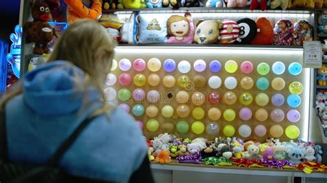 Woman Popping a Balloon with a Dart in Amusement Park Stock Footage ...