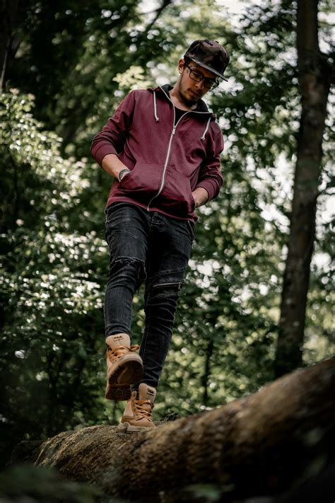 Man in Pink Hoodie and Blue Denim Jeans Jumping on Brown Tree Branch · Free Stock Photo