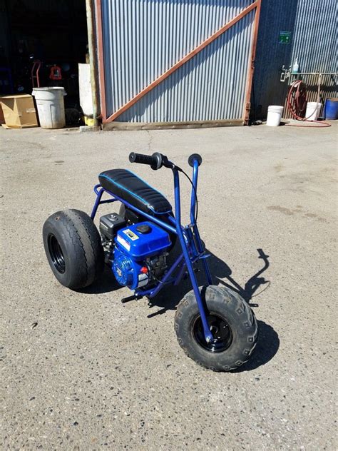 a small blue motorcycle sitting in the middle of a parking lot