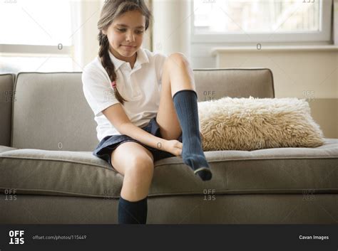 Girl putting on a sock stock photo - OFFSET