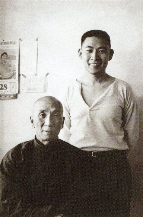 an old black and white photo of two people posing for the camera, one ...