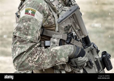 Soldier with assault rifle and flag of Myanmar and also known as Burma on military uniform ...