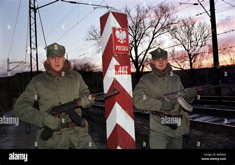 Polish border guard officers with guns at a border pole at the Polish-German border, Poland ...