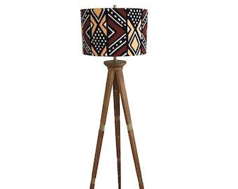 a wooden tripod floor lamp with a patterned shade