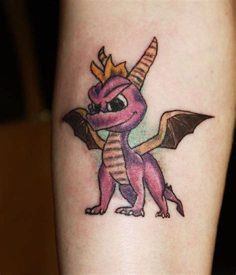 a small tattoo of a pink dragon with a gold crown on it's head