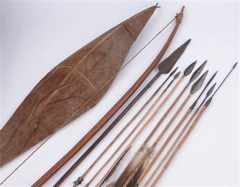 An African Tribal bow with a selection of arrows, a leather covered metal framed shield and a ste