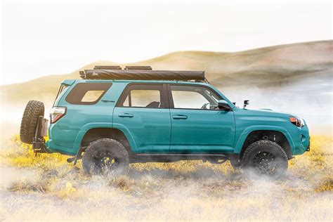 a blue four door suv parked in a field