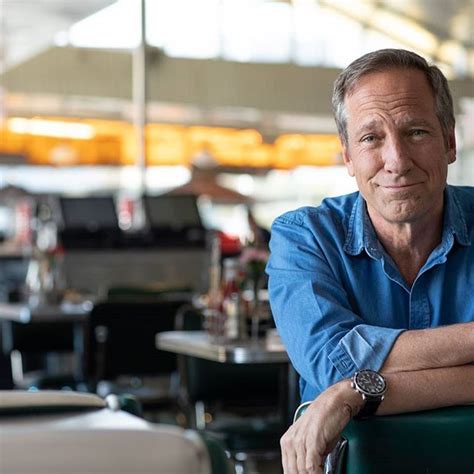 a man sitting at a table with his arms crossed and looking off to the side