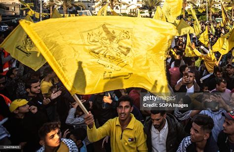 A Palestinian waves a yellow flag of Fatah movement during a festival ...