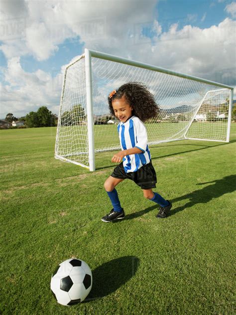 Mixed race girl playing soccer - Stock Photo - Dissolve