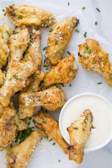 chicken wings with dipping sauce and parsley sprinkled on the side, ready to be eaten