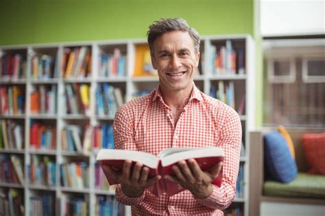 Portrait of School Teacher Holding Book in Library Stock Image - Image of caucasian, development ...