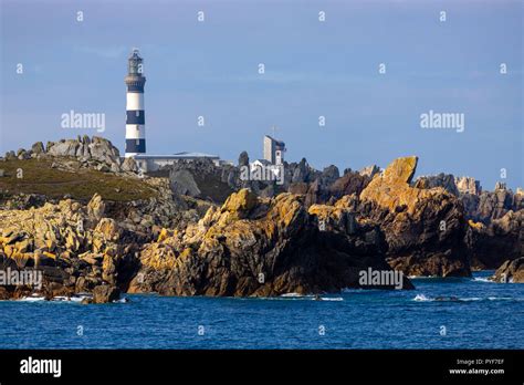 The Creach lighthouse on the sharp and rocky coastline of the Ushant island, Brittany, France ...