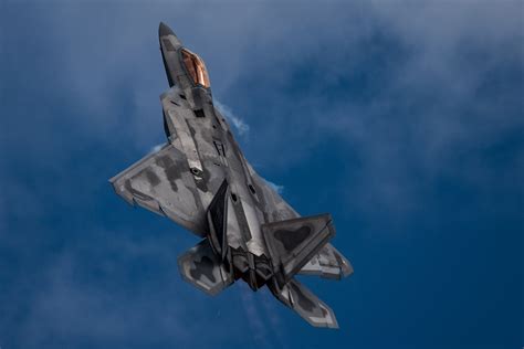 An F-22 Raptor aircraft performs a 'tail slide' maneuver during an ...