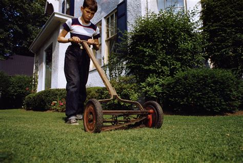 Boy Mowing Lawn posters & prints by Corbis