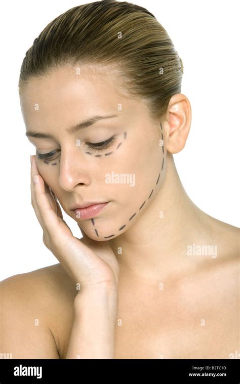 Woman with plastic surgery markings on face, hand under chin, looking down Stock Photo - Alamy