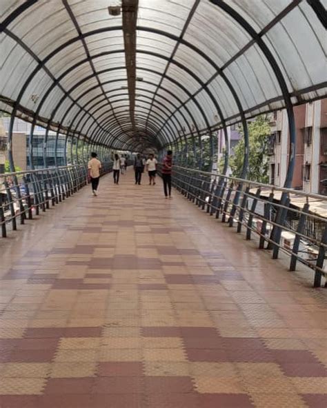 people are walking on a walkway in a glass and metal structure with ...