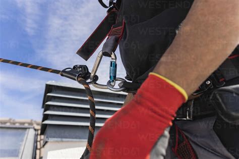 Technician wearing safety harness on roof stock photo