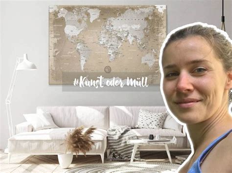 a woman standing in front of a living room with a world map on the wall