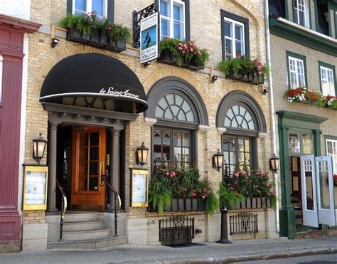 an old building with flower boxes on the front and side of it's windows