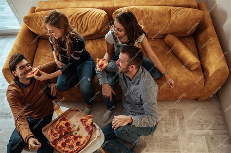 Premium Photo | Shot of a group of friends enjoying pizza together