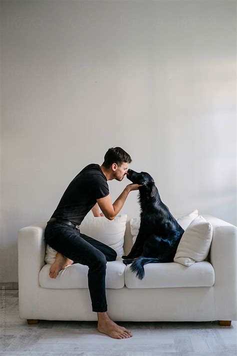 «Young Man With His Dog On A White Sofa» del colaborador de Stocksy ...