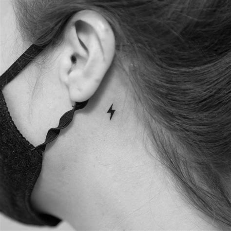 Minimalistic style lightning bolt tattoo done behind