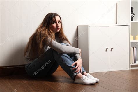 Nervous frightened young girl sits alone on floor — Stock Photo © darrinahenry #6121636