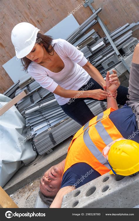 Female Paramedic Checking Pulse Rate Lying Construction Worker Injured Work Stock Photo by ©info ...