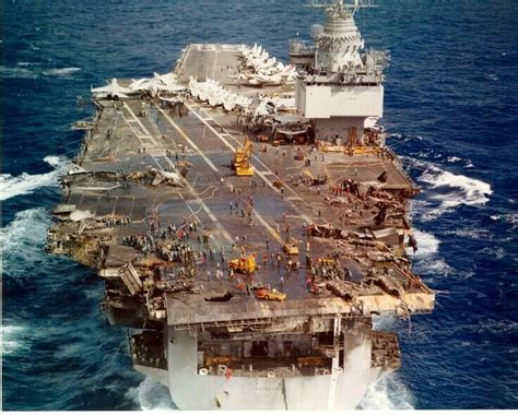 an aircraft carrier is in the middle of the ocean with other ships on it's deck