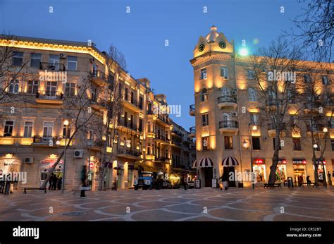 Pedestrians on the illuminated Fountain Square, historic city centre of ...