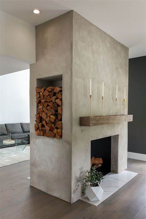 a large concrete fireplace with marble tiles, a rough wood slab, a ...