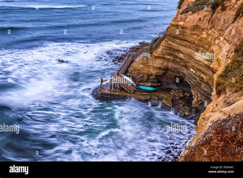 Looking down on stairs leading down a cliff to a surfing spot. Sunset ...